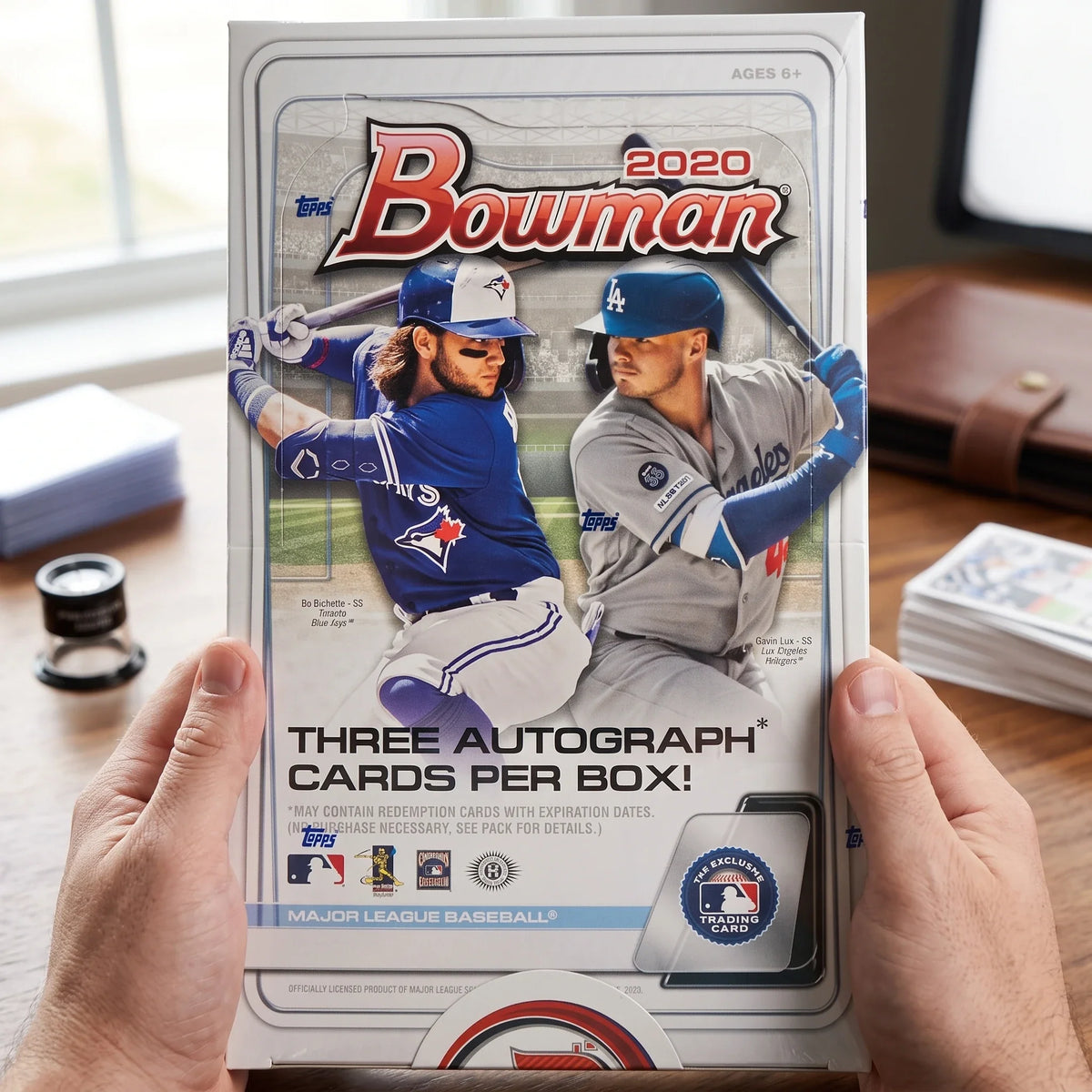 Collector hands displaying 2020 Bowman Baseball Hobby Jumbo Box | Three Chrome Autographs (Ships Sealed Only) on a premium card-shop desk.