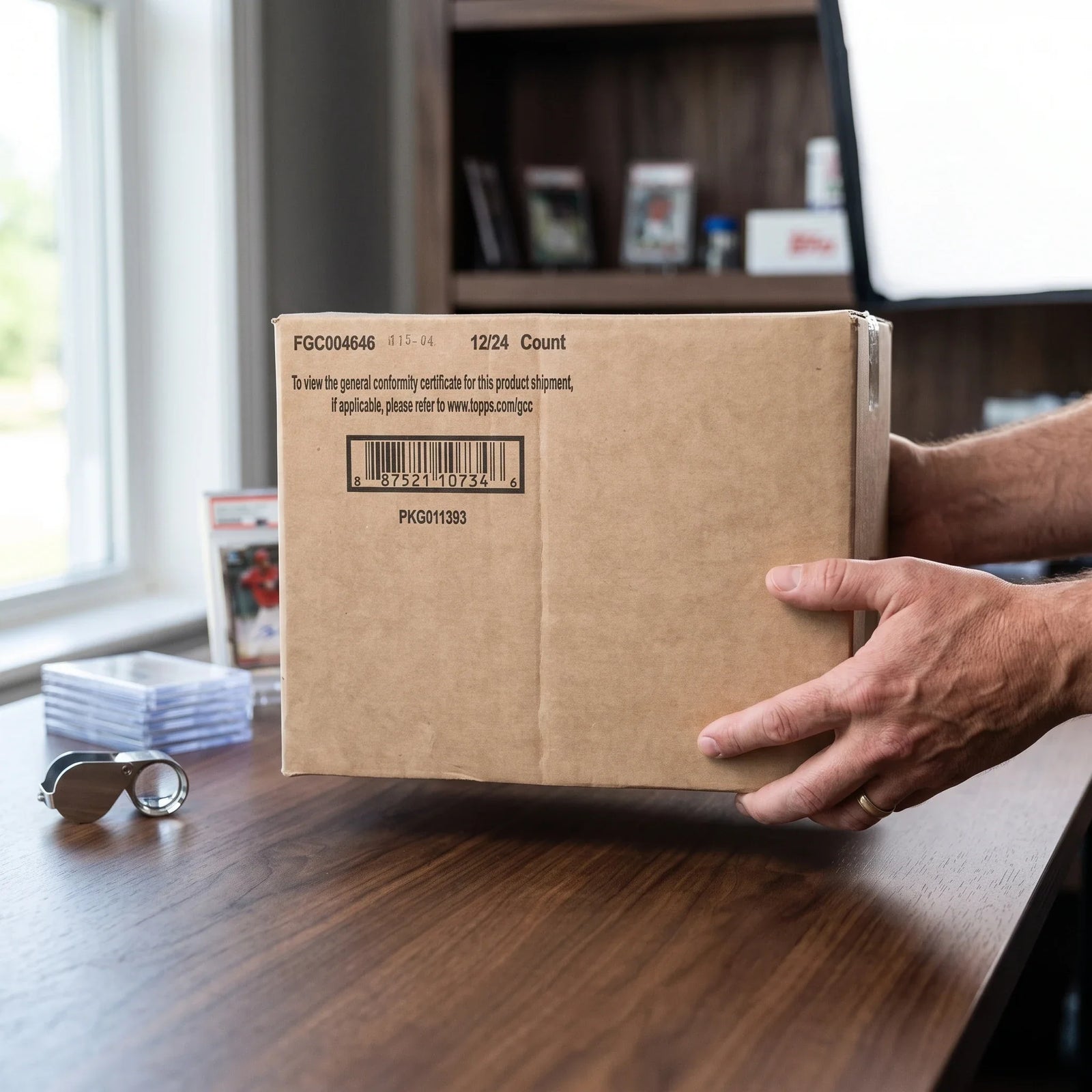 Collector hands displaying 2022 Bowman Baseball Hobby 12-Box Case (Ships Sealed Only) - D on a premium card-shop desk.