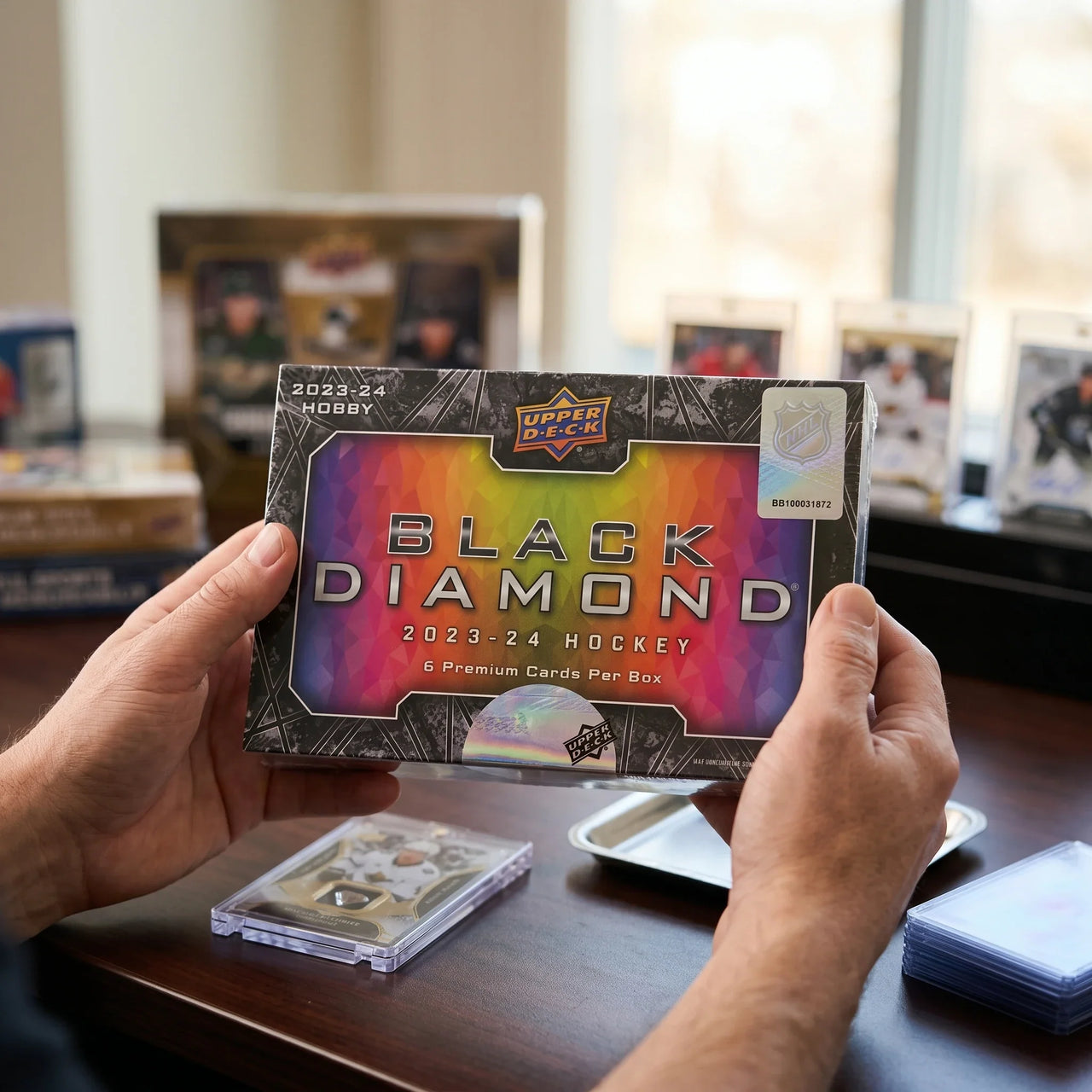 Collector hands displaying 2023-24 Upper Deck Black Diamond Hockey Trading Cards on a premium card-shop desk.