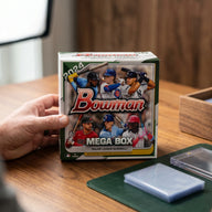 Collector hands displaying 2024 Topps Bowman Baseball Mega Trading Cards on a premium card-shop desk.