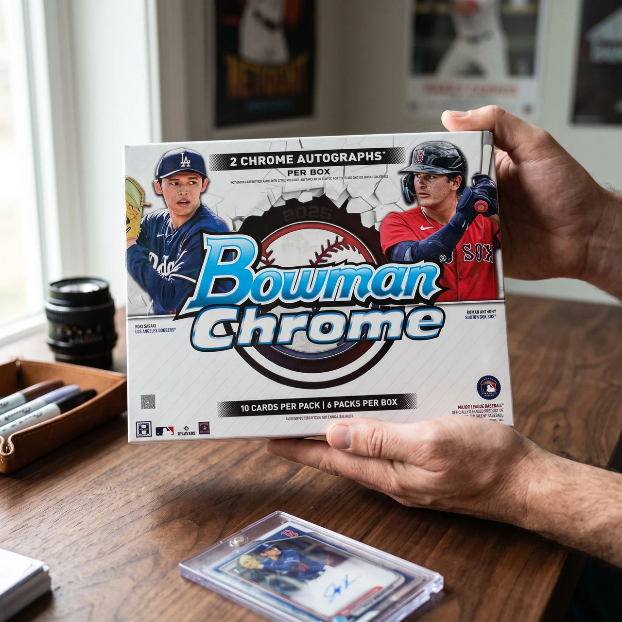 Collector hands displaying 2025 Topps Bowman Chrome Baseball Hobby Trading Cards on a premium card-shop desk.