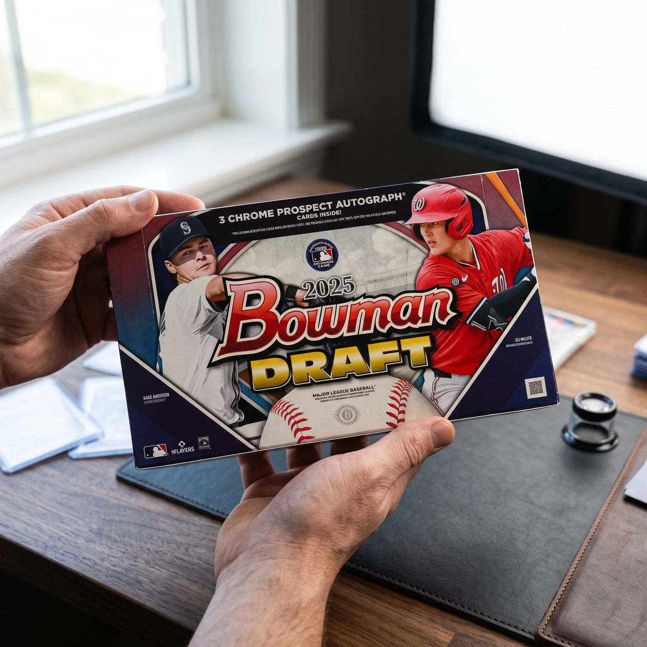 Collector hands displaying 2025 Topps Bowman Draft Baseball Hobby Jumbo Trading Cards on a premium card-shop desk.