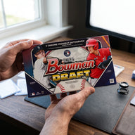 Collector hands displaying 2025 Topps Bowman Draft Baseball Hobby Jumbo Trading Cards on a premium card-shop desk.