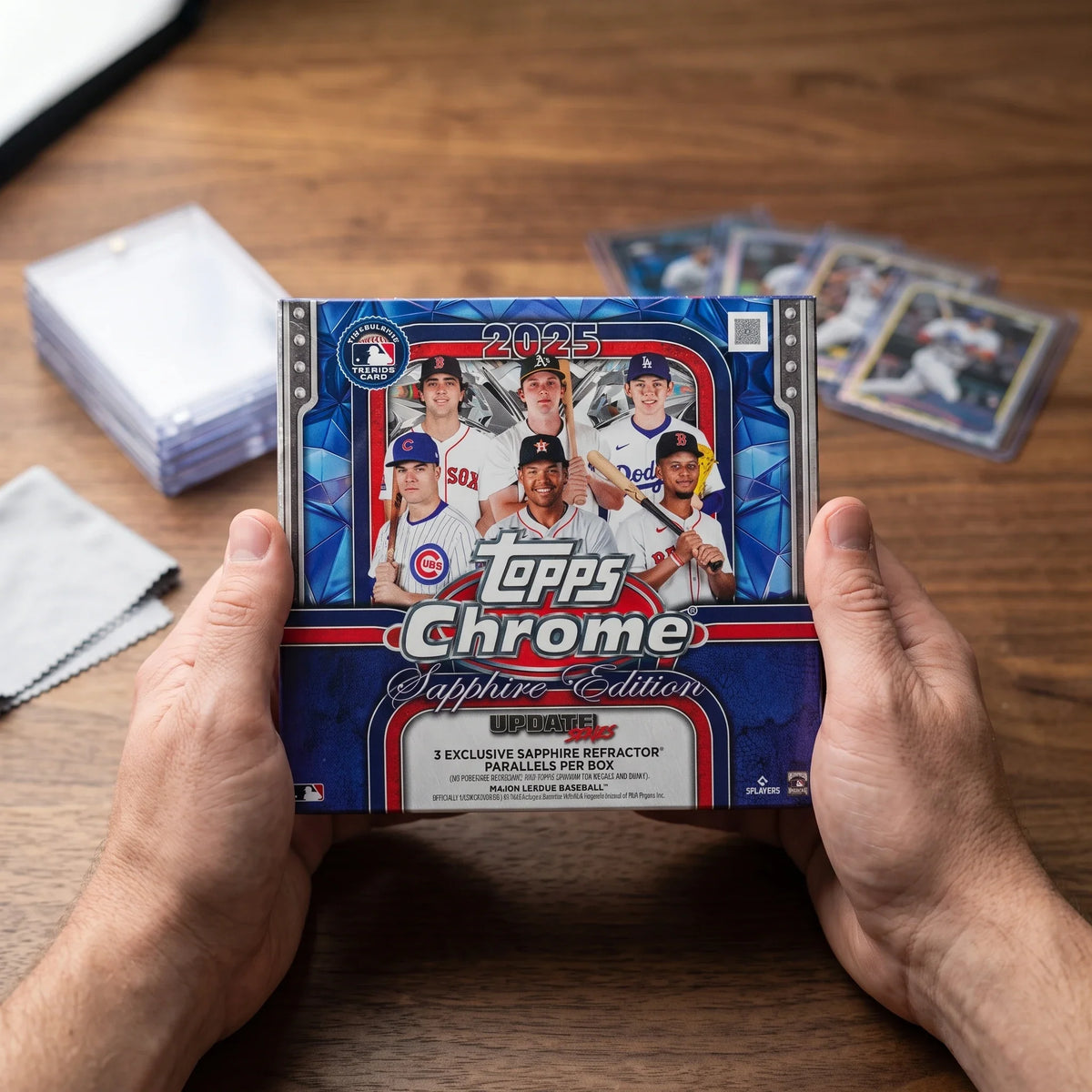 Collector hands displaying 2025 Topps Chrome Baseball Update Series Sapphire Edition Trading Cards on a premium card-shop desk.